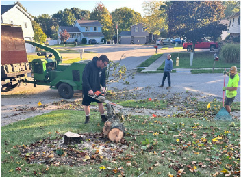 Shown: Miller’s Professional Tree Services cleaning up branches and debris after removing a large tree and stump.